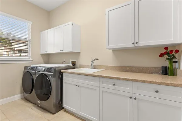 a utility room with cabinets washer and dryer