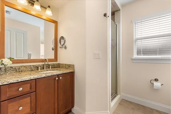 a bathroom with a granite countertop sink and a mirror