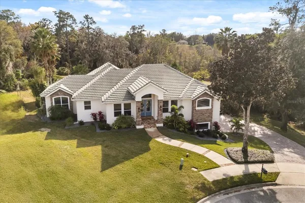 a view of a white house with a yard patio and swimming pool