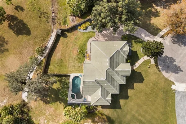 an aerial view of residential house with outdoor space and trees