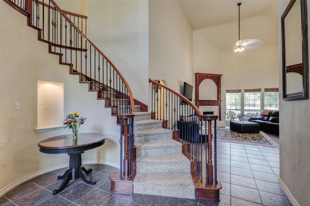 10414 Broadmoor Lane Rowlett, TX 75089 - Photo 4 of 38 Stairs with a high ceiling, a fireplace, and tile patterned flooring