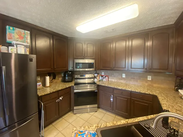 a kitchen with granite countertop stainless steel appliances and wooden cabinets
