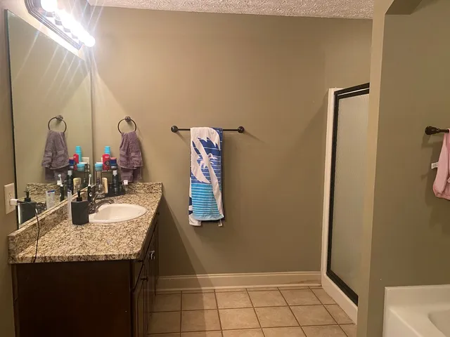 a bathroom with a granite countertop sink and a mirror