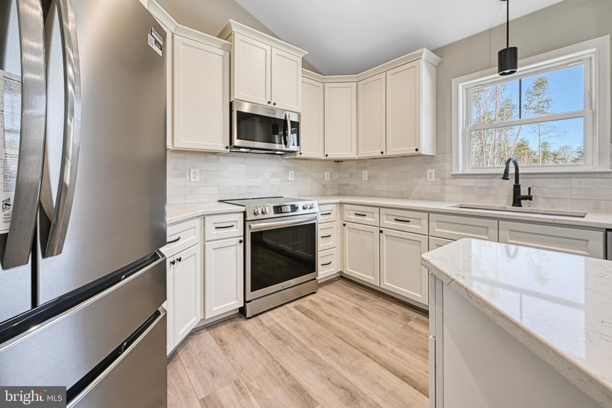 48 Pine Drive Louisa, VA 23093 - Photo 12 of 76 a kitchen with stainless steel appliances granite countertop white cabinets a sink a stove a refrigerator and white cabinets