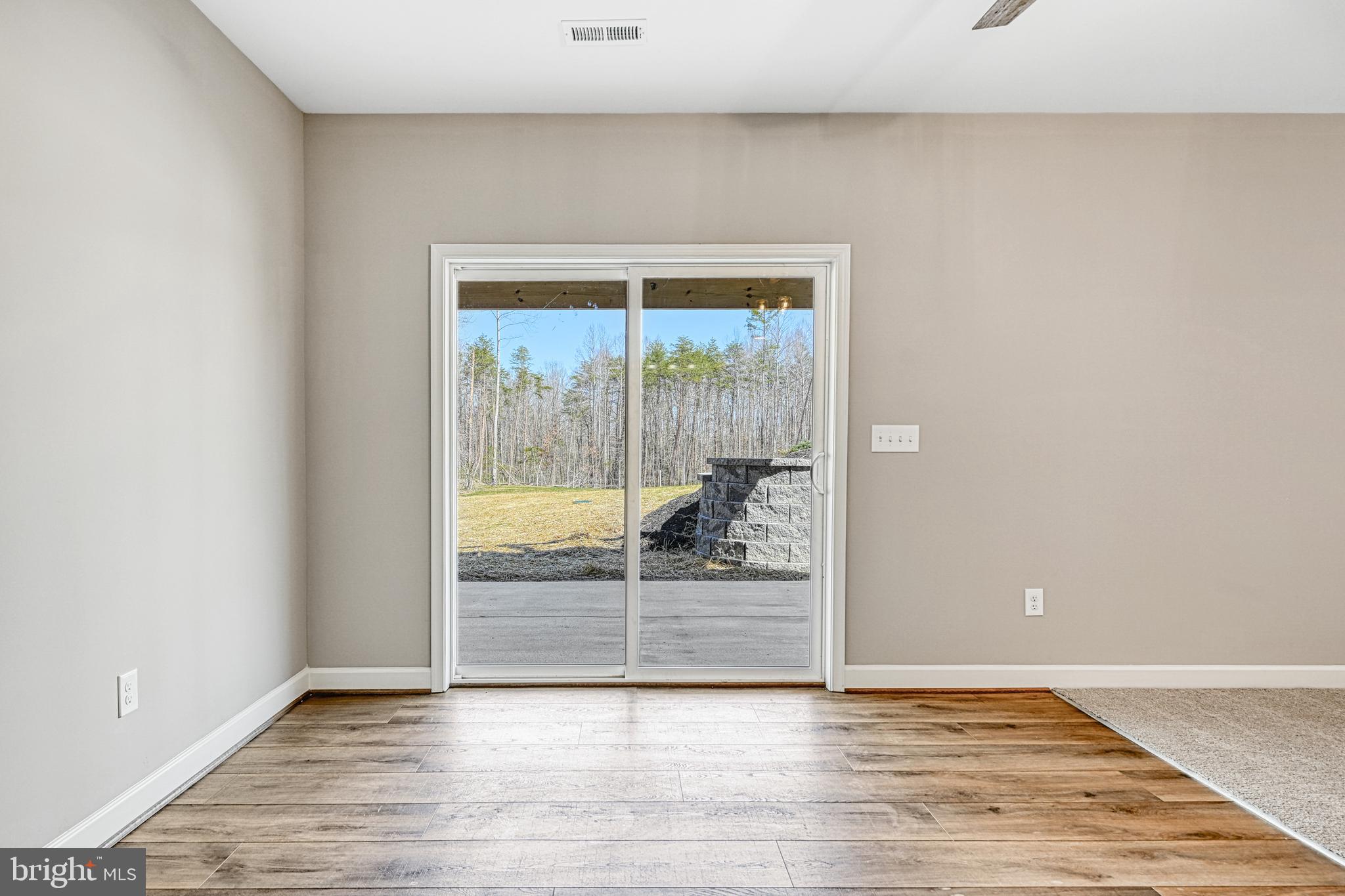 48 Pine Drive Louisa, VA 23093 - Photo 46 of 76 a view of an empty room with wooden floor and a window
