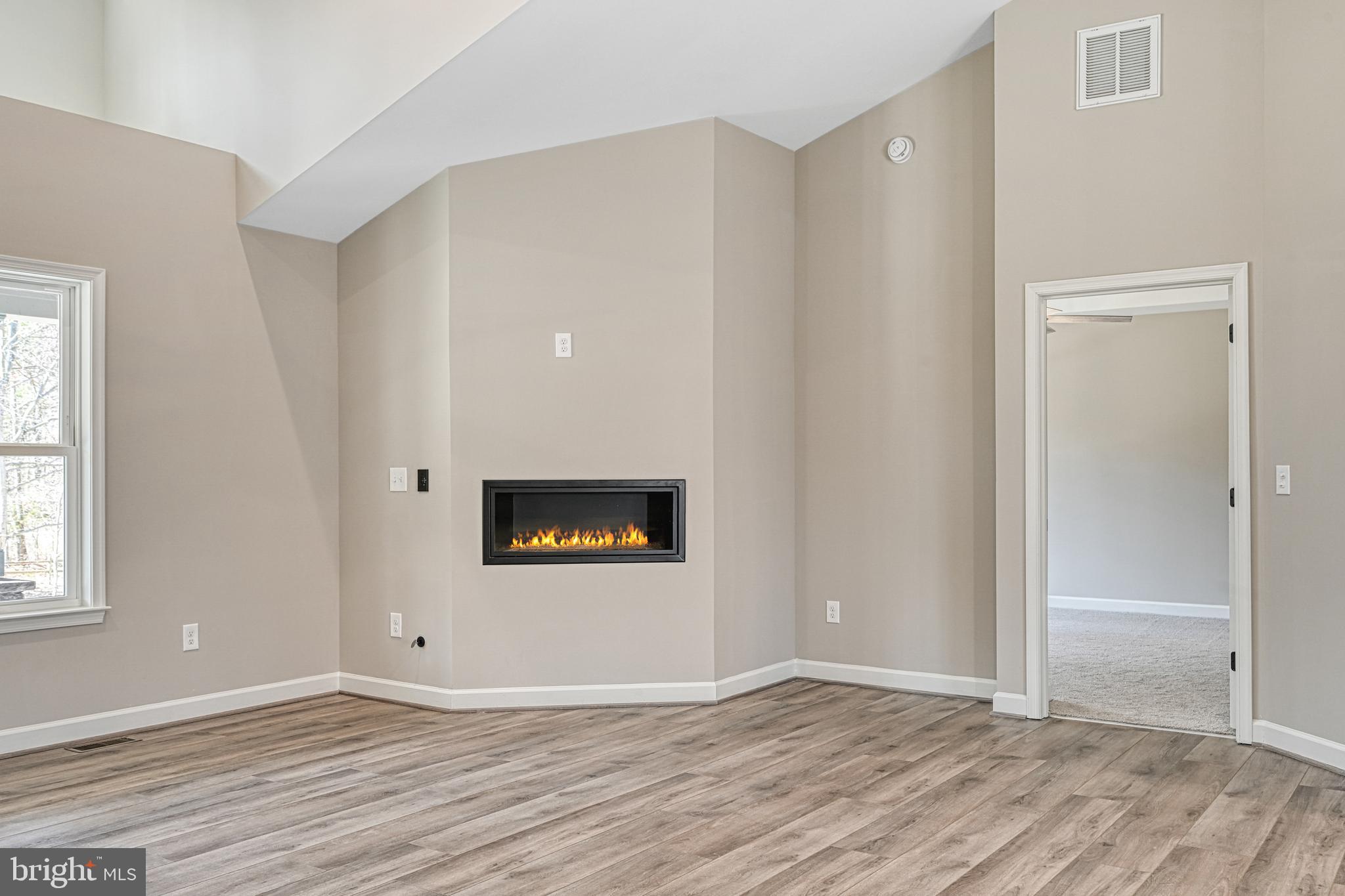 48 Pine Drive Louisa, VA 23093 - Photo 8 of 76 a view of an empty room with wooden floor and a window