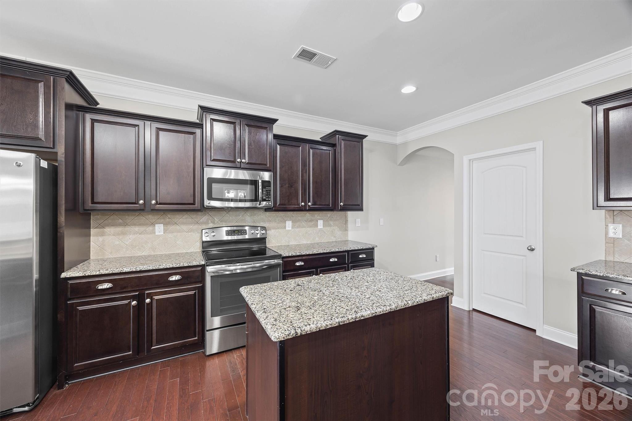 1129 Black Walnut Road Clover, SC 29710 - Photo 16 of 40 a kitchen with granite countertop cabinets stainless steel appliances and wooden floor
