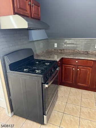 a kitchen with granite countertop a stove and a cabinets