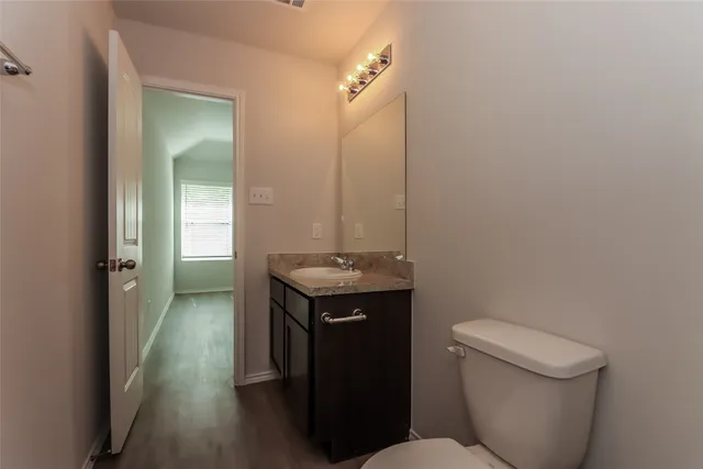 a bathroom with a granite countertop sink a toilet and a mirror