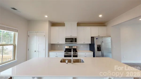 a kitchen with stainless steel appliances a refrigerator and a stove top oven