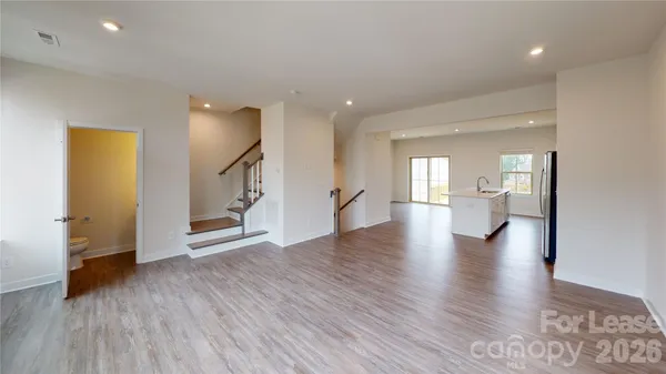 a view of an empty room and wooden floor and a cabinet