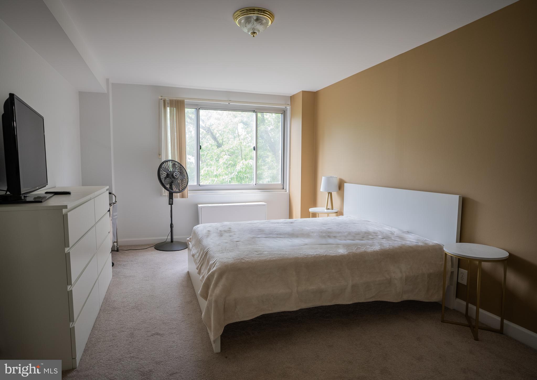 1900 Lyttonsville Road, Unit 514 Silver Spring, MD 20910 - Photo 4 of 5 a bedroom with a bed tv and a window