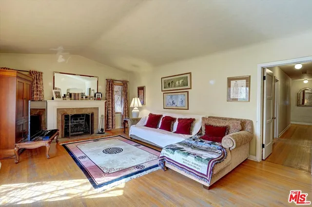 a living room with furniture flat screen tv and a large window