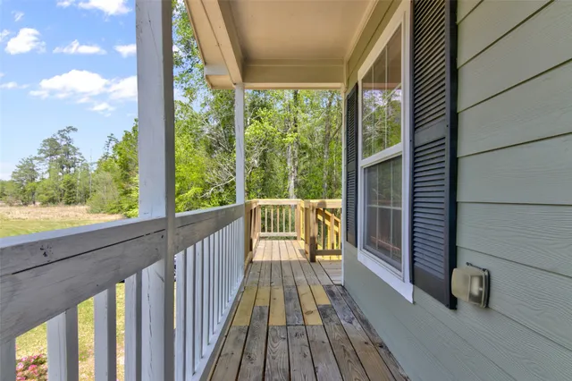 a view of balcony with wooden floor and fence