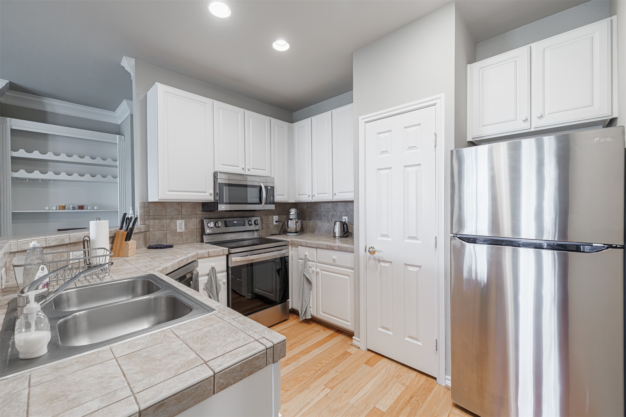 2400 McCue Road, Unit 308 Houston, TX 77056 - Photo 6 of 24 a kitchen with white cabinets and refrigerator