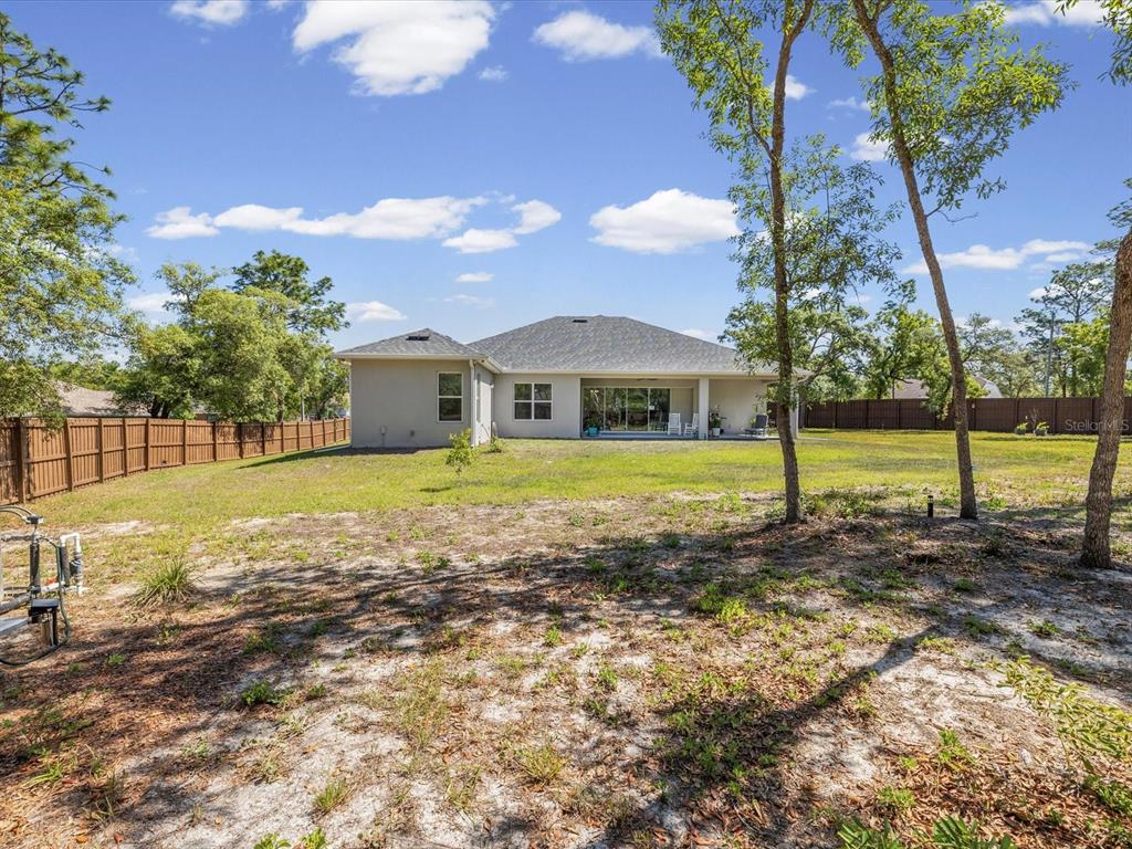 11981 Robina Road Weeki Wachee, FL 34614 - Photo 62 of 93 a view of a house with backyard and tree s