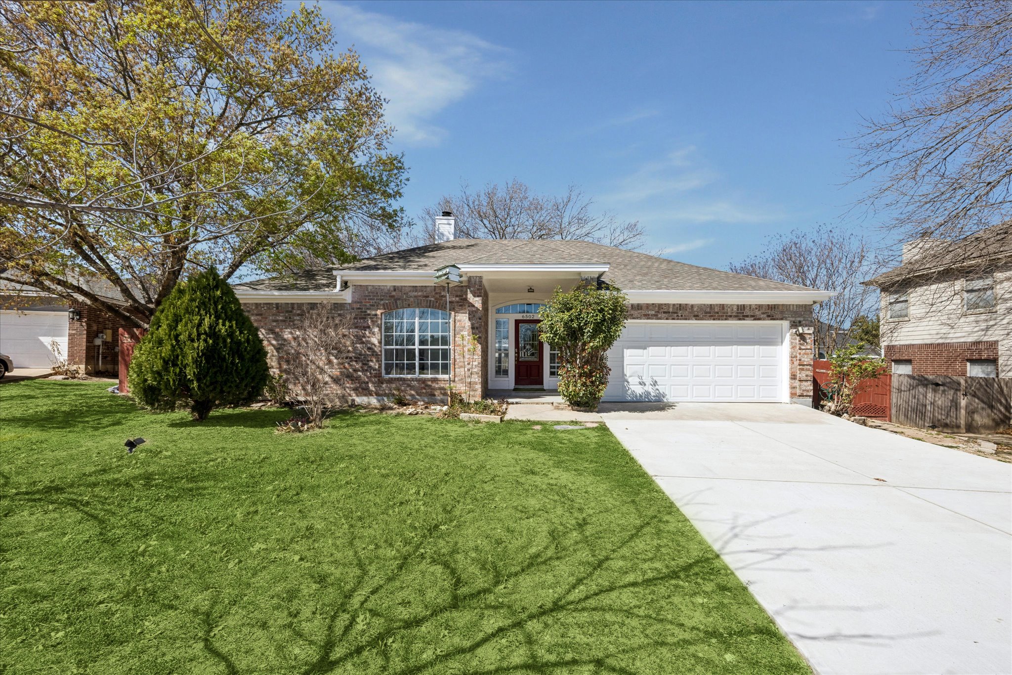a front view of a house with a garden and trees
