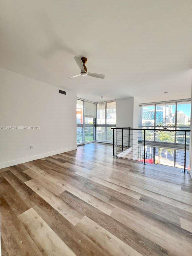 90 Southwest 3rd Street, Unit TH300A Miami, FL 33130 - Photo 12 of 21 a view of empty room with wooden floor and floor to ceiling window