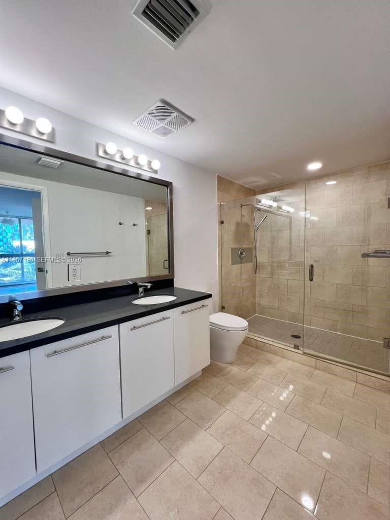 90 Southwest 3rd Street, Unit TH300A Miami, FL 33130 - Photo 14 of 21 a bathroom with a double vanity sink toilet and shower