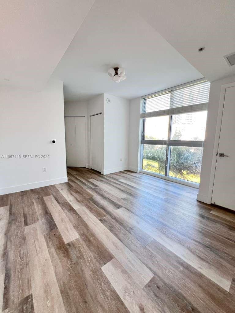90 Southwest 3rd Street, Unit TH300A Miami, FL 33130 - Photo 15 of 21 wooden floor in an empty room with a window