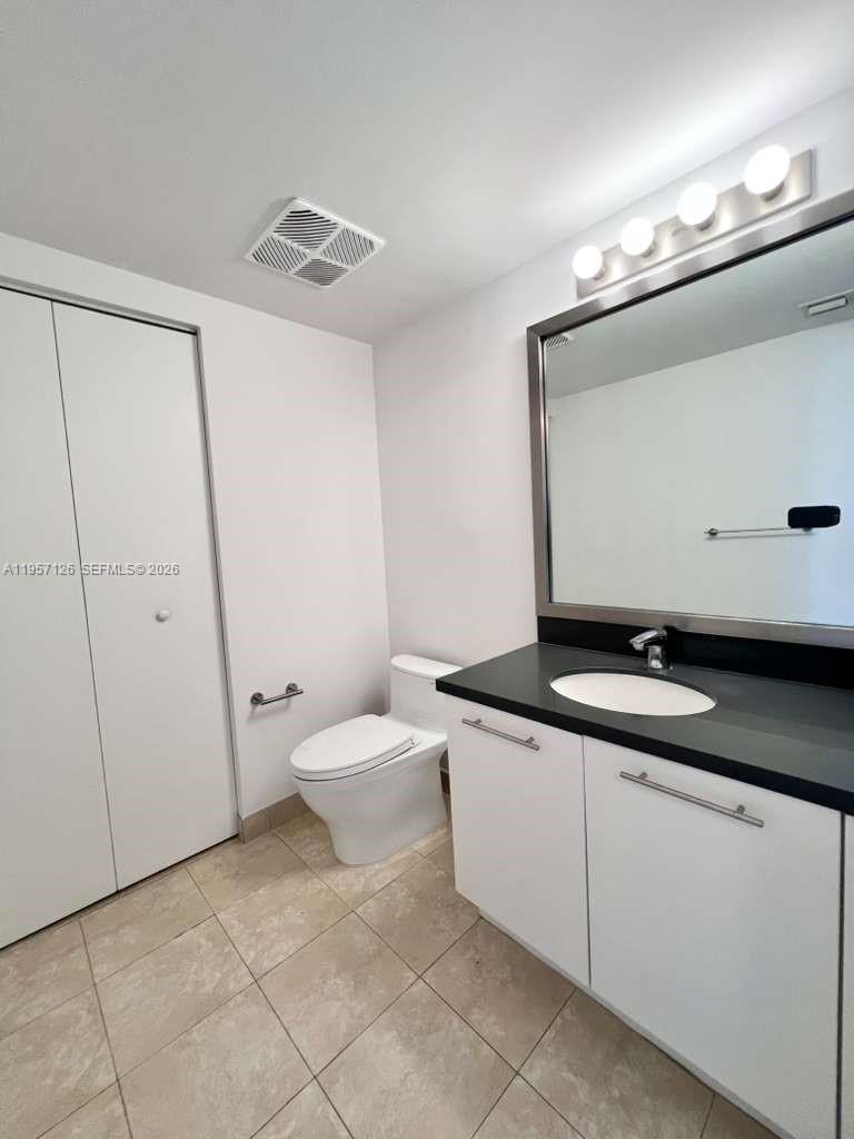 90 Southwest 3rd Street, Unit TH300A Miami, FL 33130 - Photo 10 of 21 a bathroom with a granite countertop sink a toilet and mirror