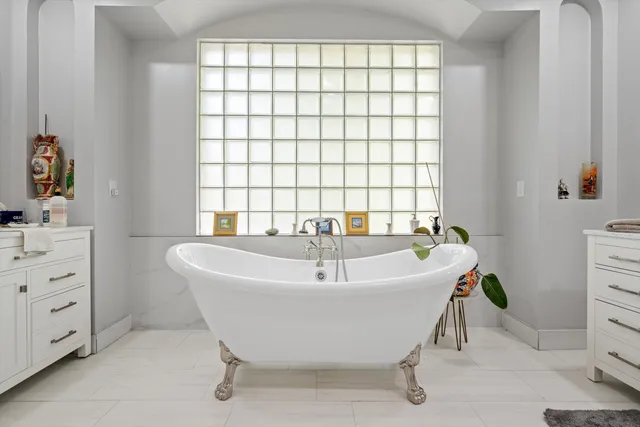 a spacious bathroom with a double vanity sink mirror and bathtub