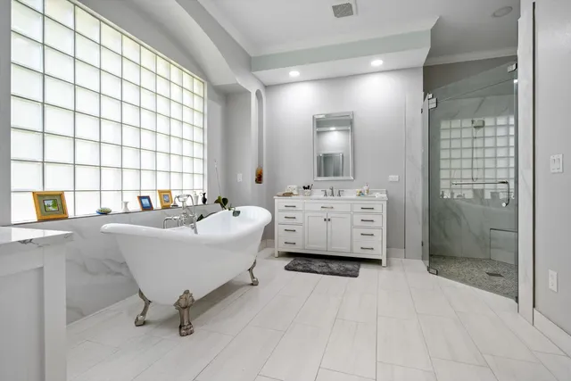 a spacious bathroom with a bathtub sink and mirror