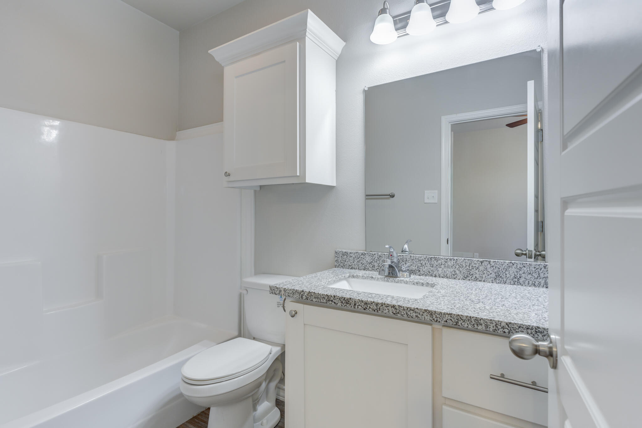3404 25th Street Lubbock, TX 79410 - Photo 26 of 38 a bathroom with a granite countertop sink a toilet and a mirror