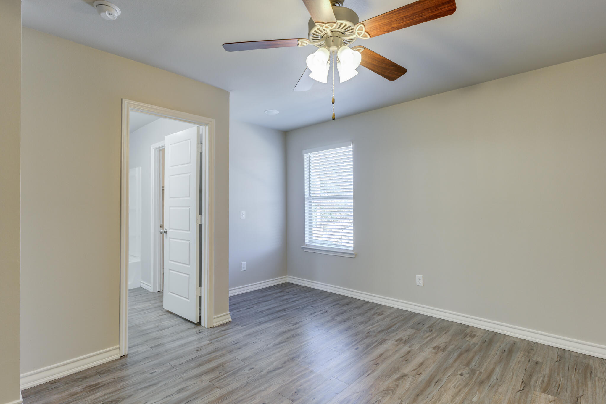 3404 25th Street Lubbock, TX 79410 - Photo 30 of 38 an empty room with wooden floor chandelier fan and windows