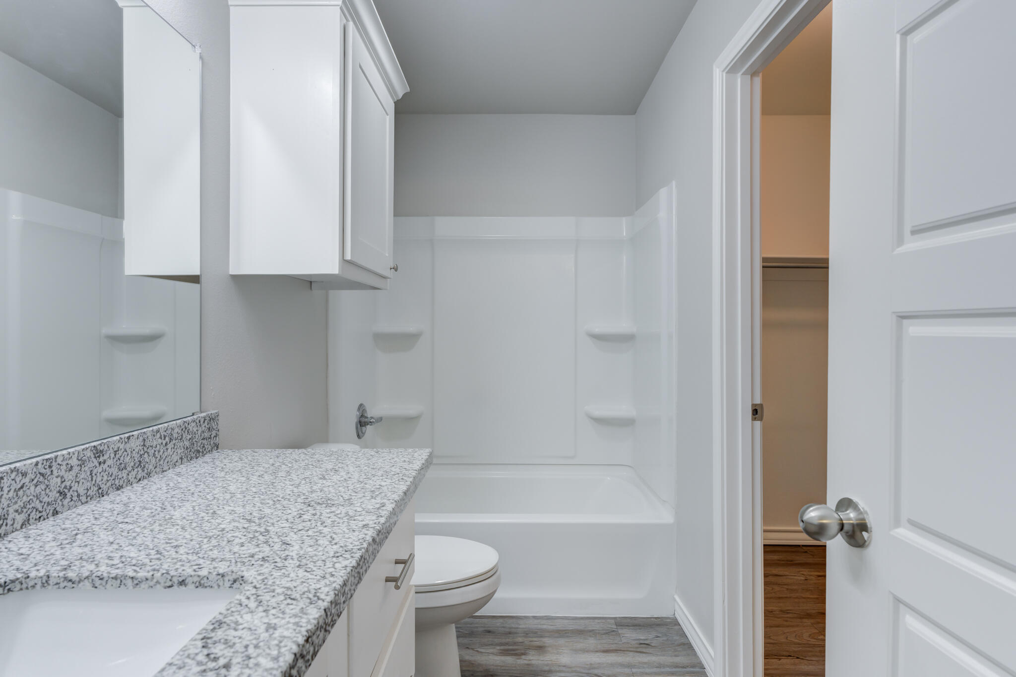 3404 25th Street Lubbock, TX 79410 - Photo 31 of 38 a bathroom with a granite countertop sink a toilet and bathtub
