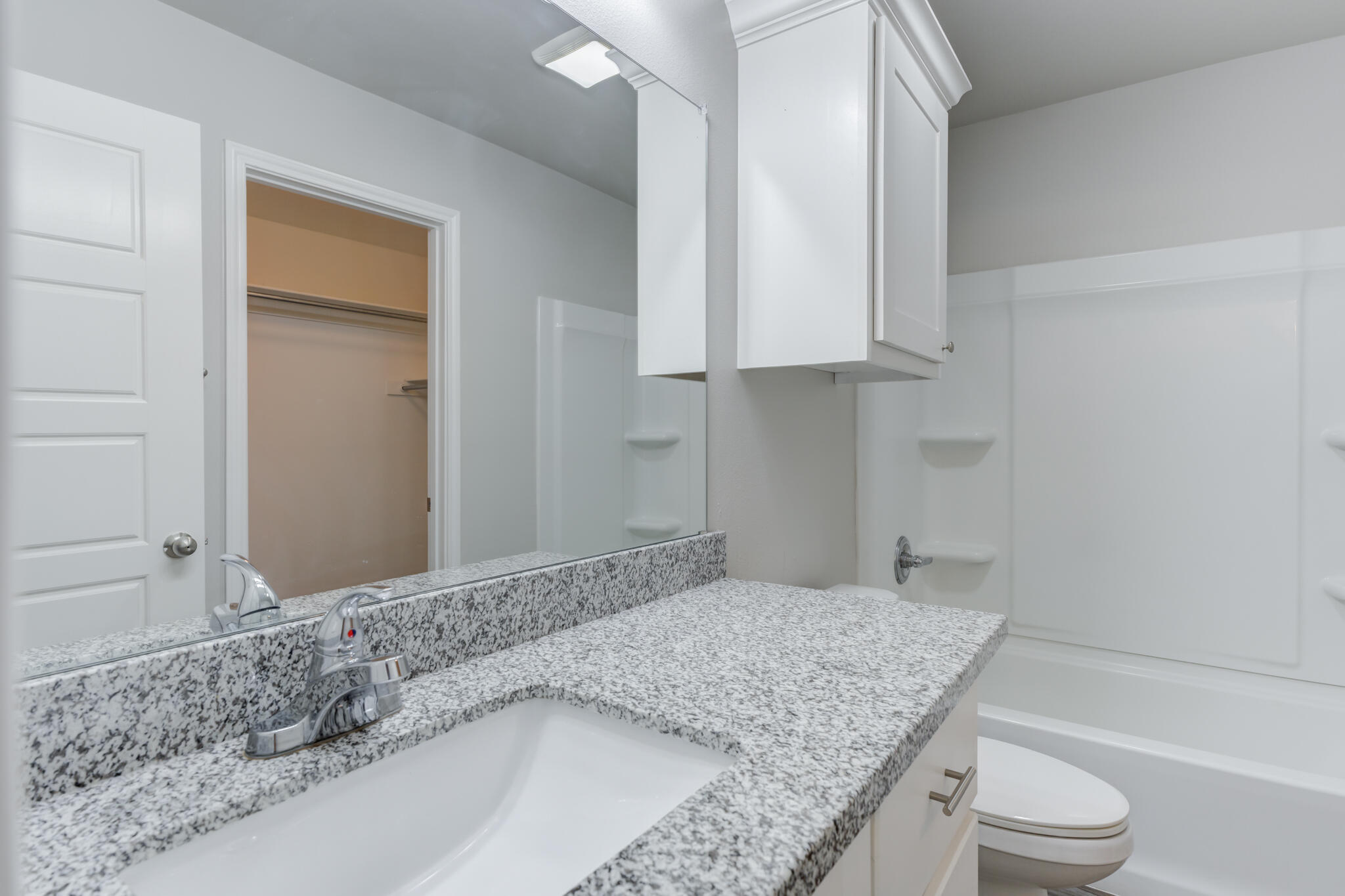 3404 25th Street Lubbock, TX 79410 - Photo 32 of 38 a bathroom with a granite countertop sink a toilet and vanity