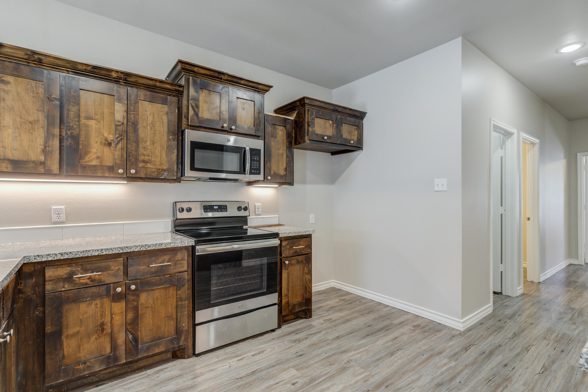 3404 25th Street Lubbock, TX 79410 - Photo 8 of 38 a kitchen with stainless steel appliances granite countertop a stove microwave and sink