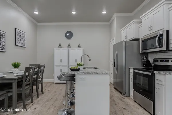 a kitchen with stainless steel appliances granite countertop a stove a sink a microwave and a refrigerator