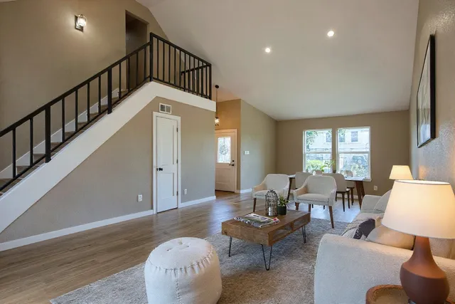 an empty room with wooden floor fireplace and windows