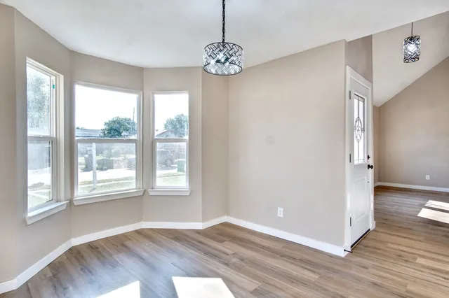 a dining room with furniture a large window and wooden floor