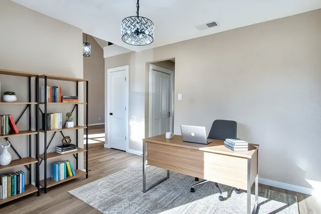 an empty room with wooden floor a ceiling fan and carpet