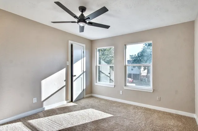 a view of a hallway with a ceiling fan