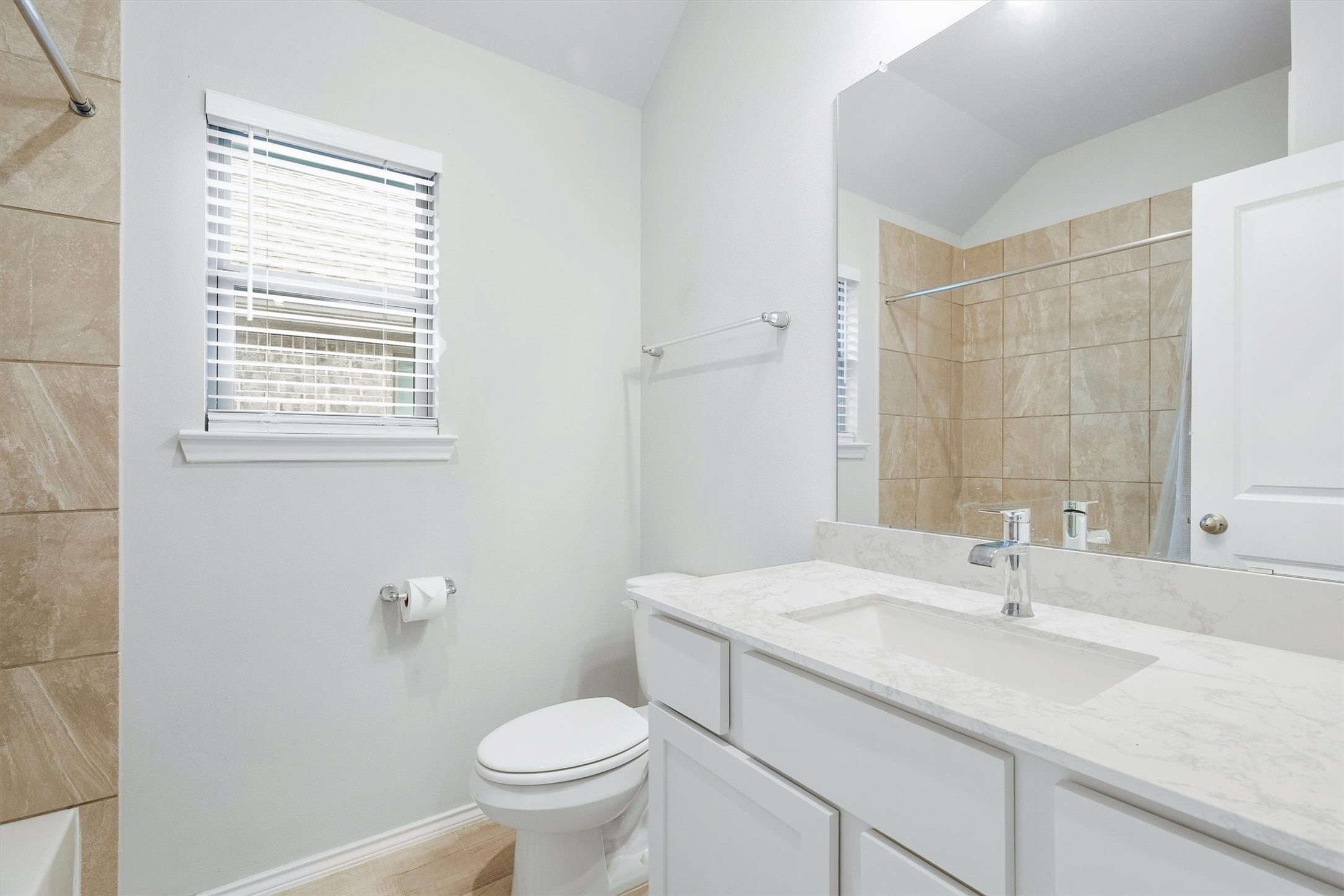 17270 Wild Watermelon Way Conroe, TX 77302 - Photo 18 of 28 Clean, bright, and well appointed. The secondary bath features a stone countertop vanity, large mirror, vaulted ceiling, and a window for natural light. Guests will feel right at home.