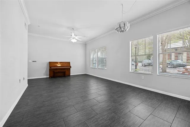 an empty room with windows and ceiling fan