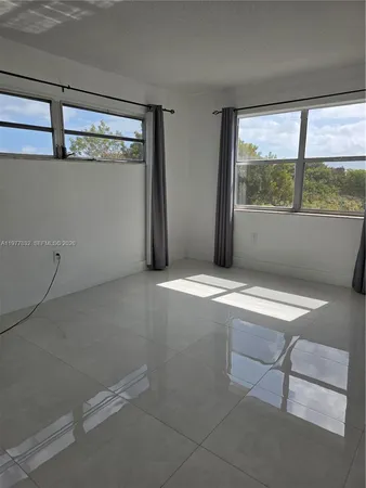 a view of an empty room with a fireplace and a window