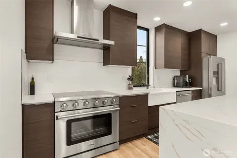 a kitchen with stainless steel appliances white cabinets and a stove top oven