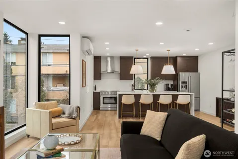 a living room with stainless steel appliances kitchen island granite countertop furniture and a view of kitchen