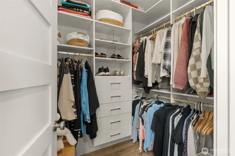 a view of walk in closet with clothes and shoes