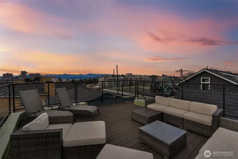 a view of a roof deck with couches and sky view