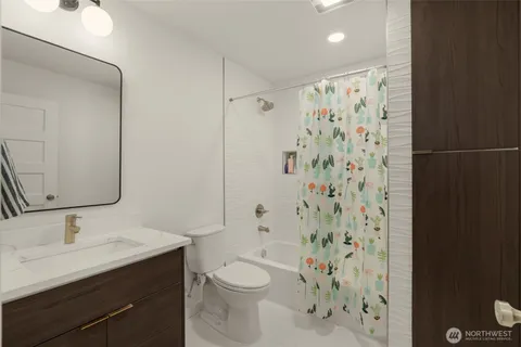a bathroom with a sink a toilet and shower curtain