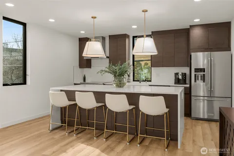 a kitchen with granite countertop a table chairs refrigerator and microwave