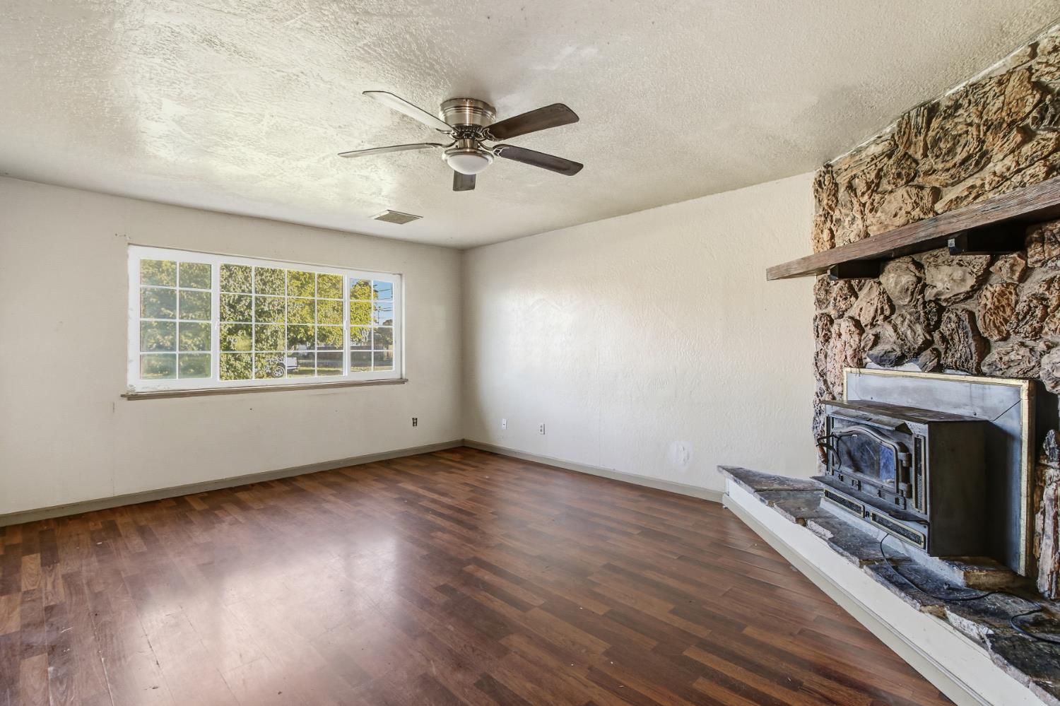 7334 Doc Adams Road Marysville, CA 95901 - Photo 4 of 30 a view of an empty room with wooden floor fireplace and a window