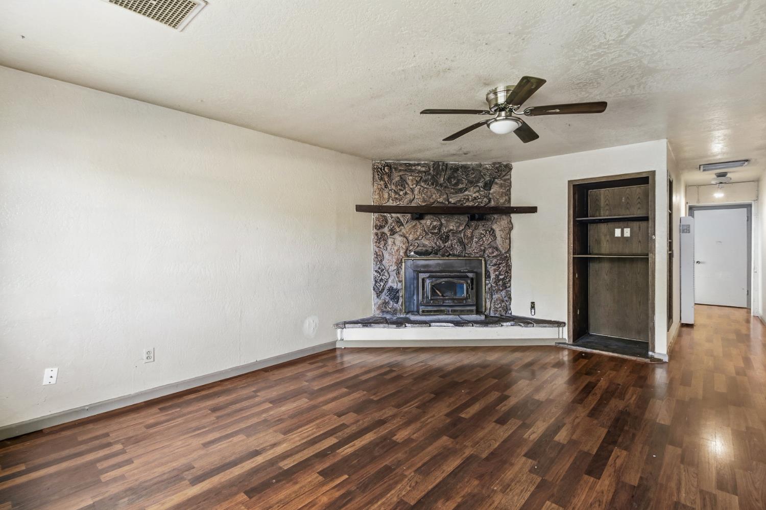 7334 Doc Adams Road Marysville, CA 95901 - Photo 6 of 30 a view of a livingroom with a fireplace and a ceiling fan