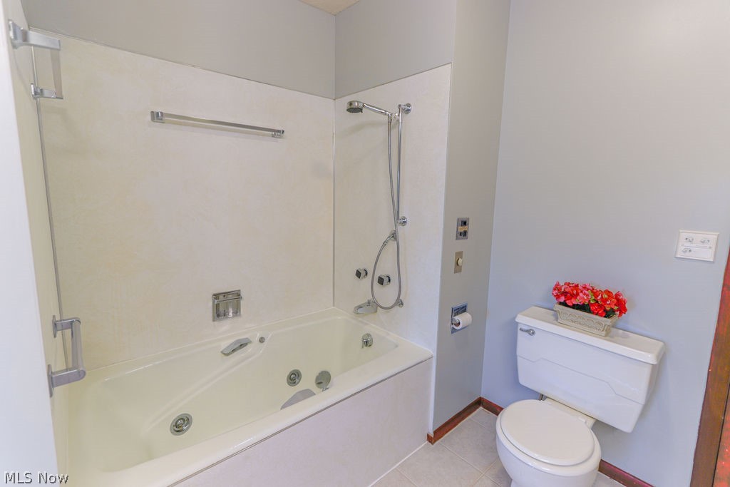 51883 Telegraph Road Amherst, OH 44001 - Photo 13 of 49 Bathroom featuring tile patterned floors, toilet, and shower / bathing tub combination