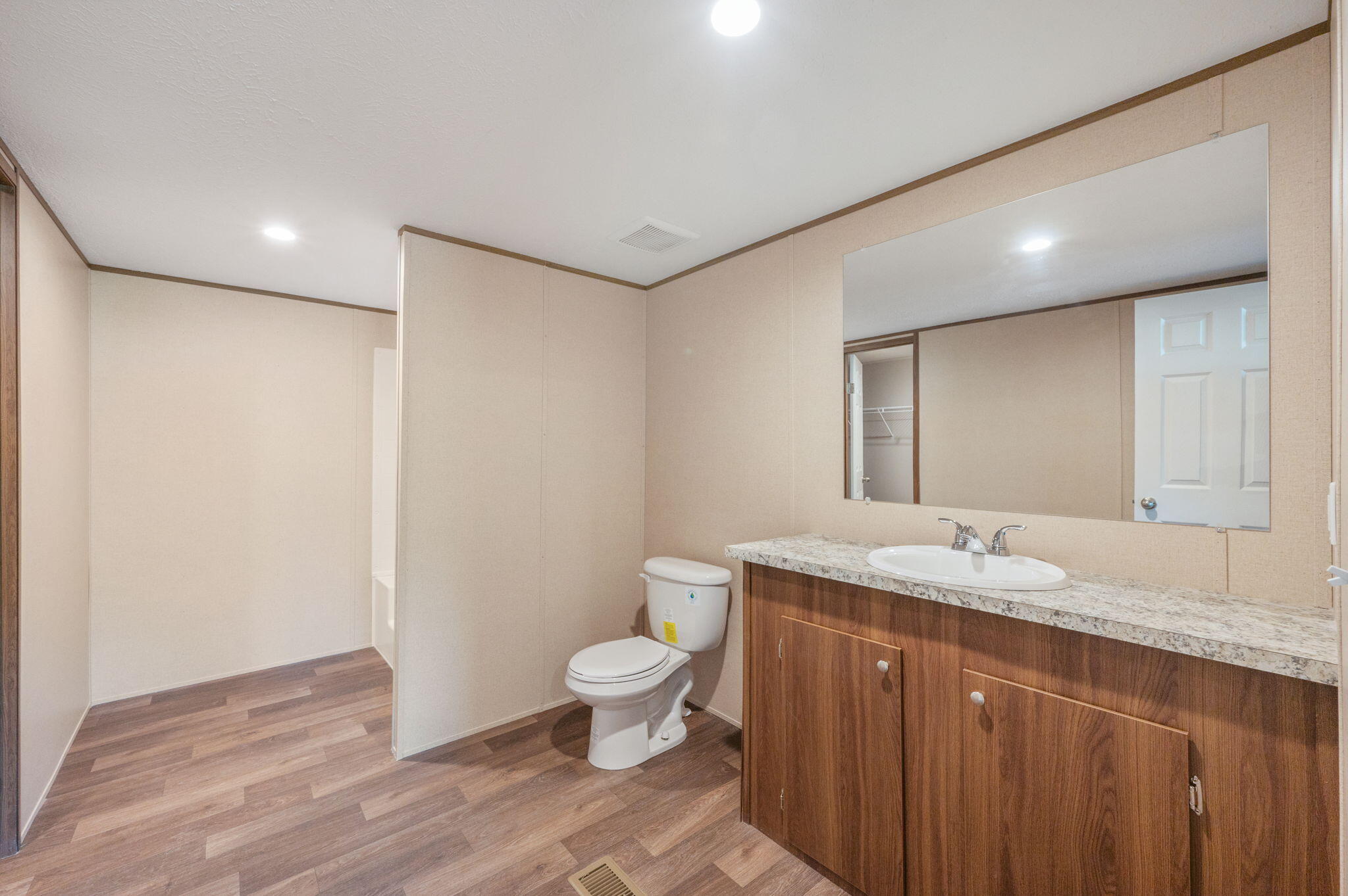 8255 Punjob Road Milton, FL 32583 - Photo 27 of 37 a bathroom with a granite countertop sink a toilet and a mirror